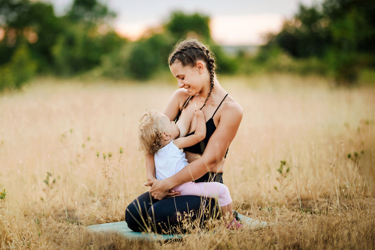Young mother breastfeeding in the nature