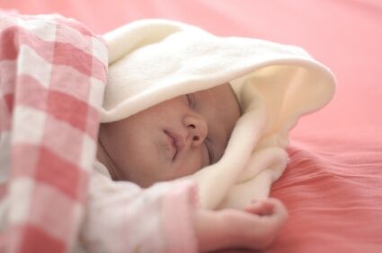 Infant sleeping in pink bedding