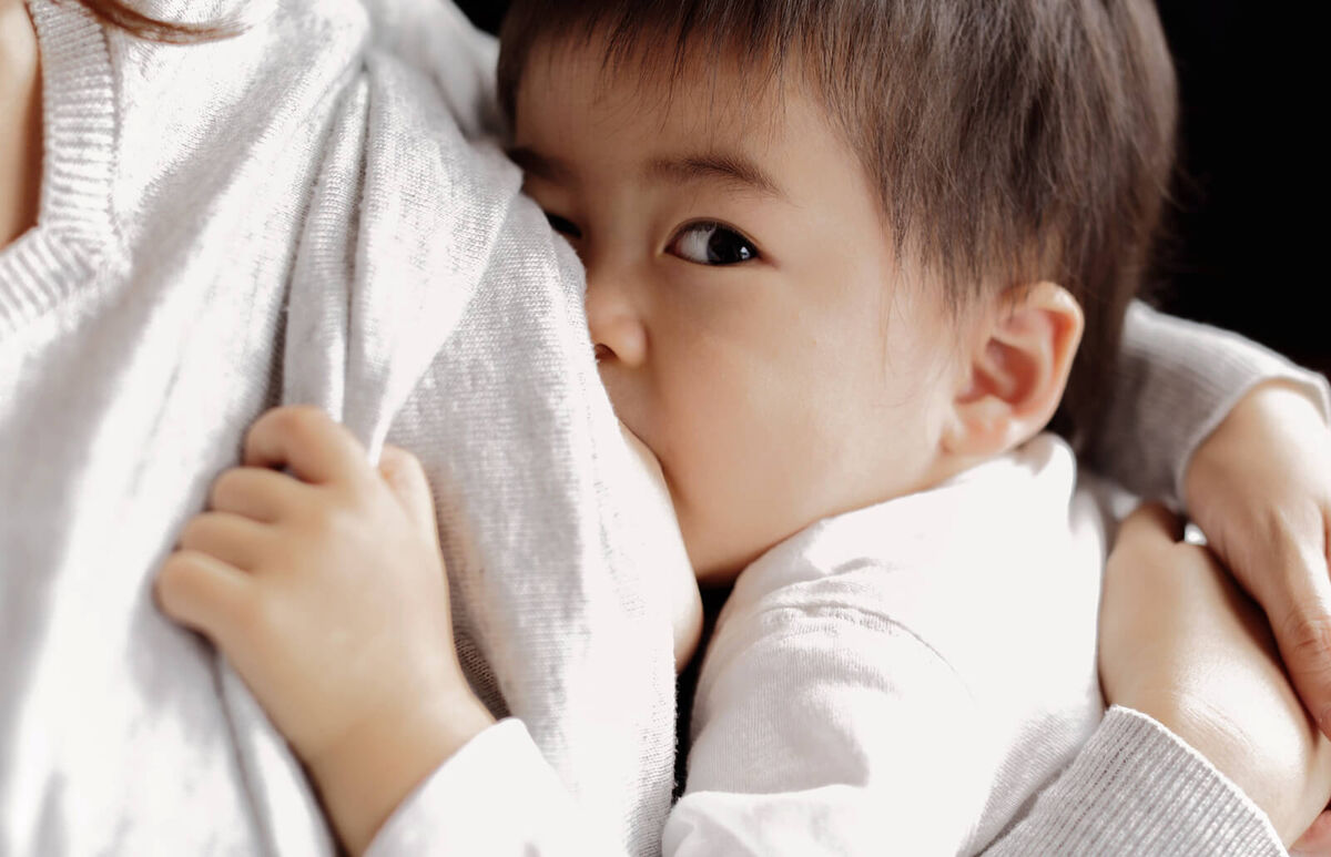Baby boy being breastfeeding fed