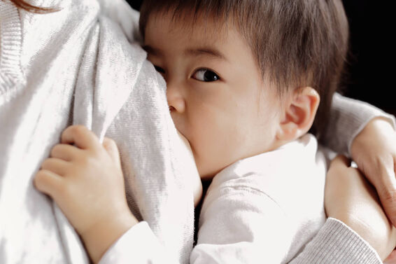 Baby boy being breastfeeding fed