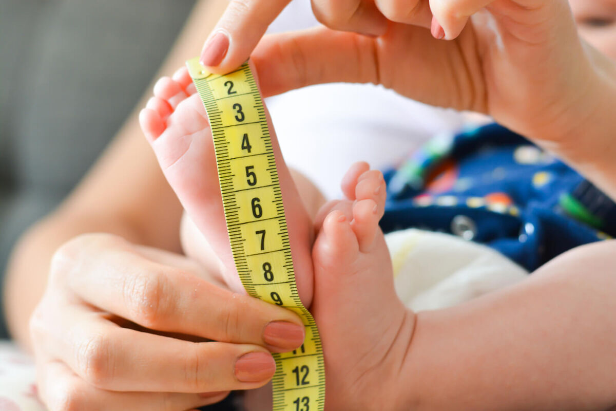 measuring tiny baby foot with a meter