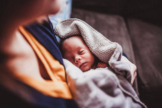 Newborn Baby is Held By Mother