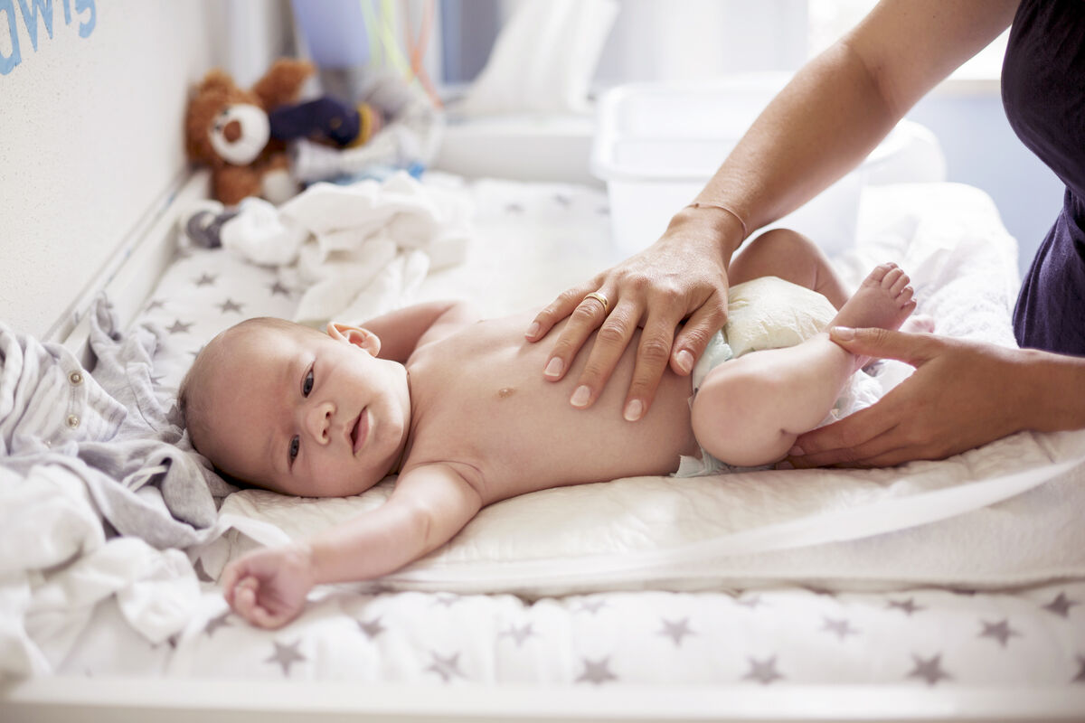 Mothers hand massaging baby son