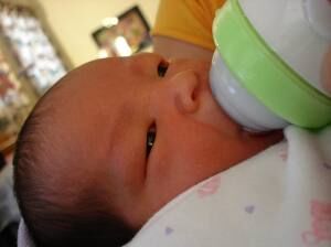 Newborn baby being bottle fed