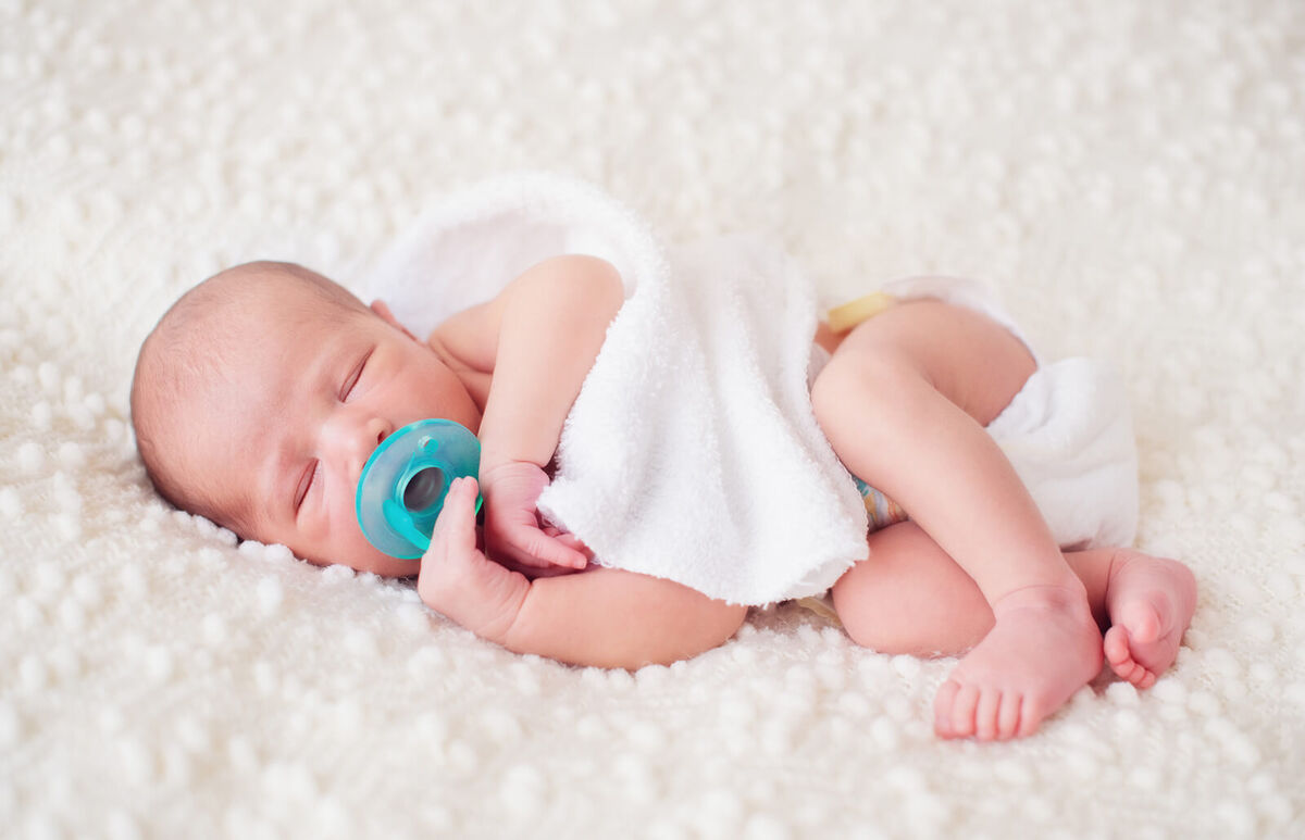 Newborn baby sleeping with pacifier