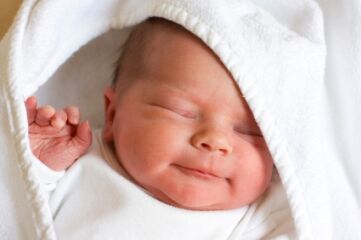 newborn baby in white blanket