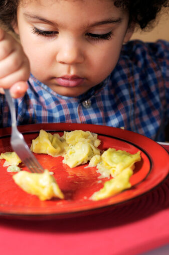 Kid eating pasta