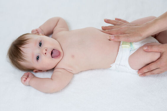 Mother giving baby stomach massage