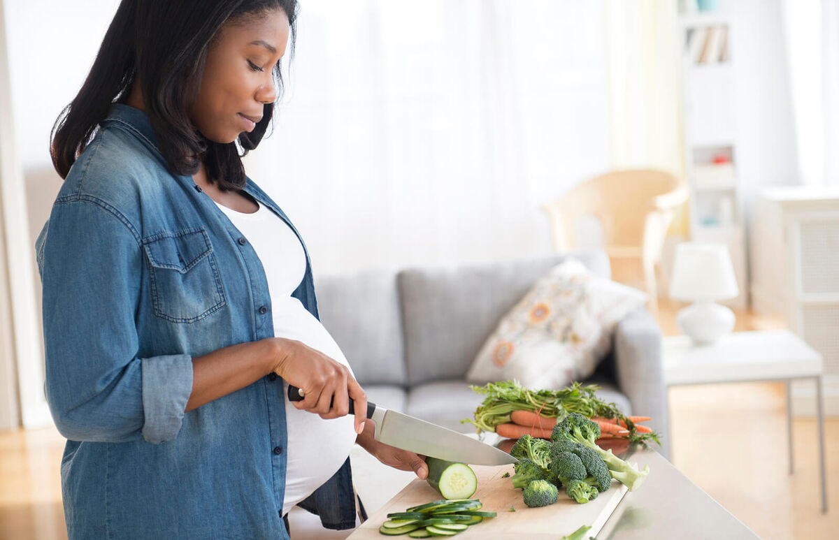 Pregnant woman chopping vegetables
