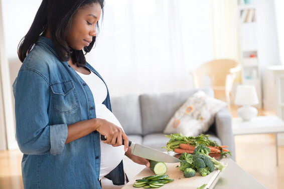 Pregnant woman chopping vegetables