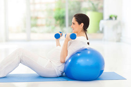 Pregnant woman exercising with dumbbells