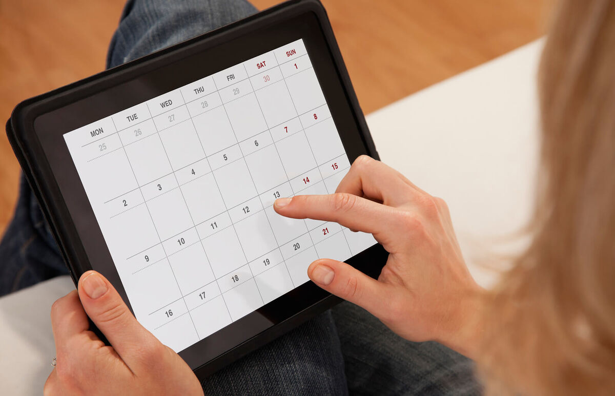 woman using calendar on digital tablet