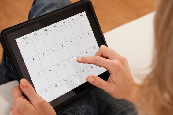woman using calendar on digital tablet