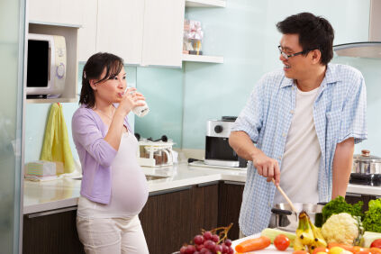Pregnant couple preparing dinner