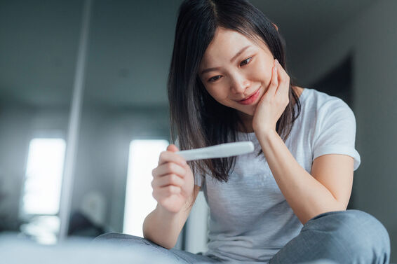Young woman holding home pregnancy test