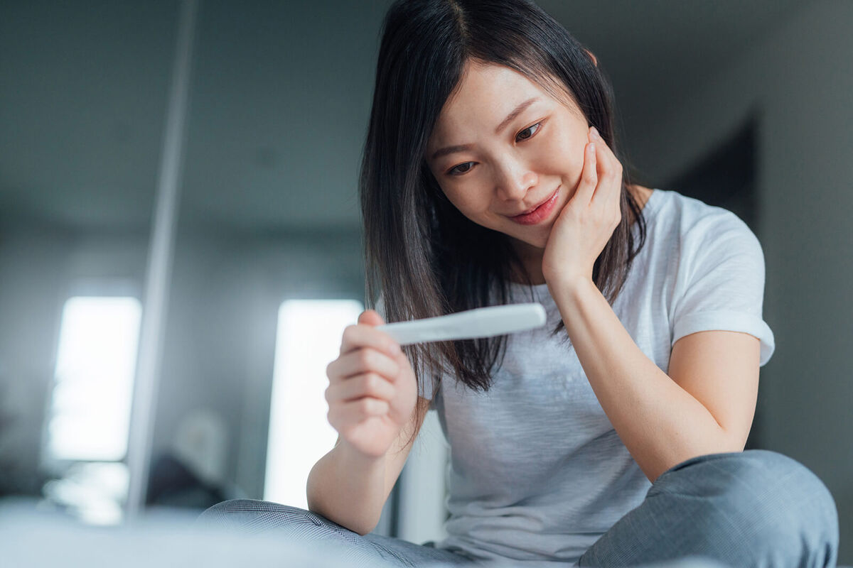 Young woman holding home pregnancy test