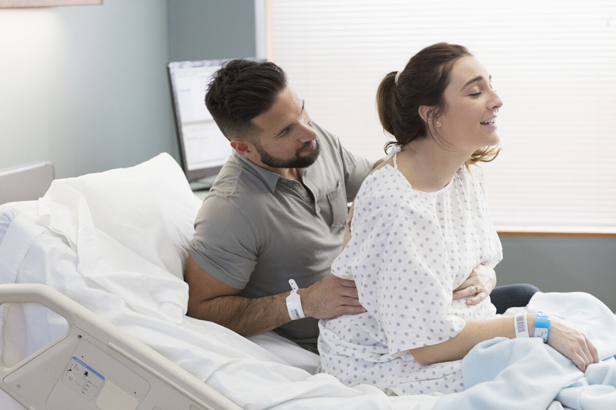Man massaging partner's back during active labor