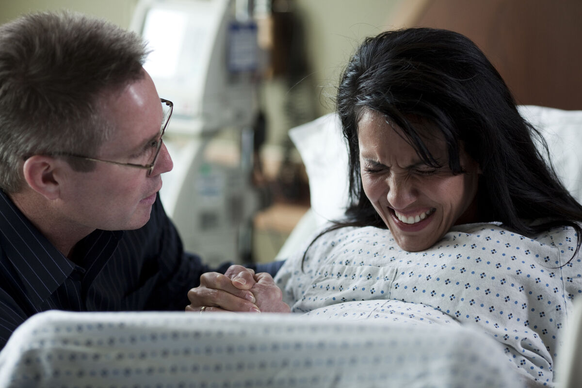woman in labor pushing with partner coaching