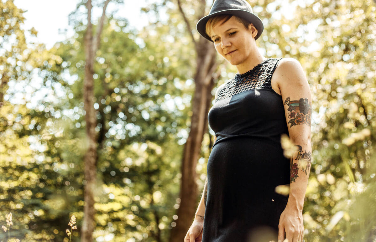Pregnant Woman Standing on Meadow in Forest