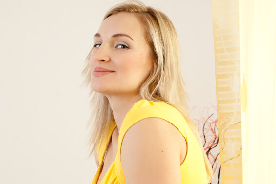 Pregnant woman wearing a yellow knit top