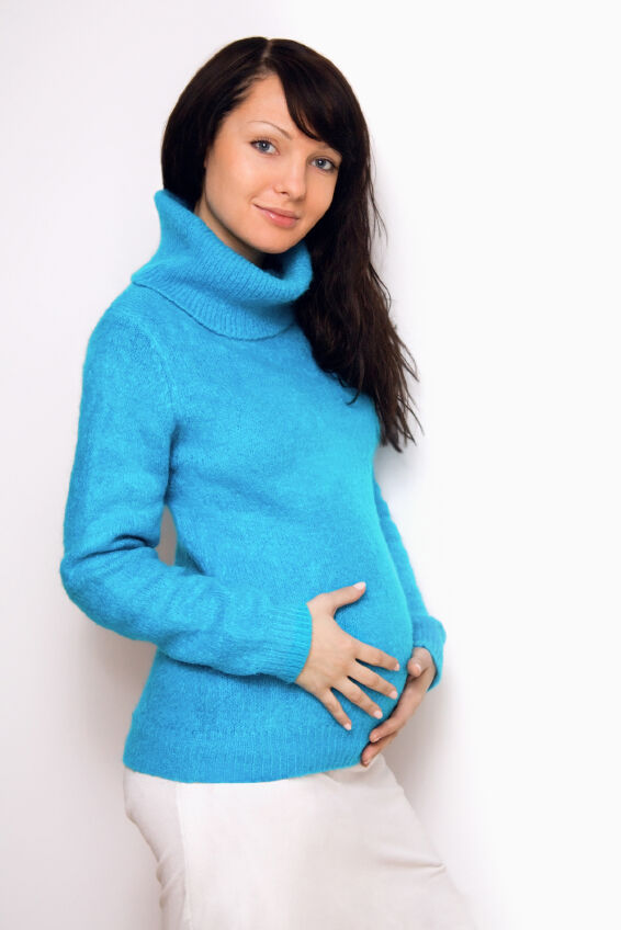 Young woman in a cozy blue maternity sweater
