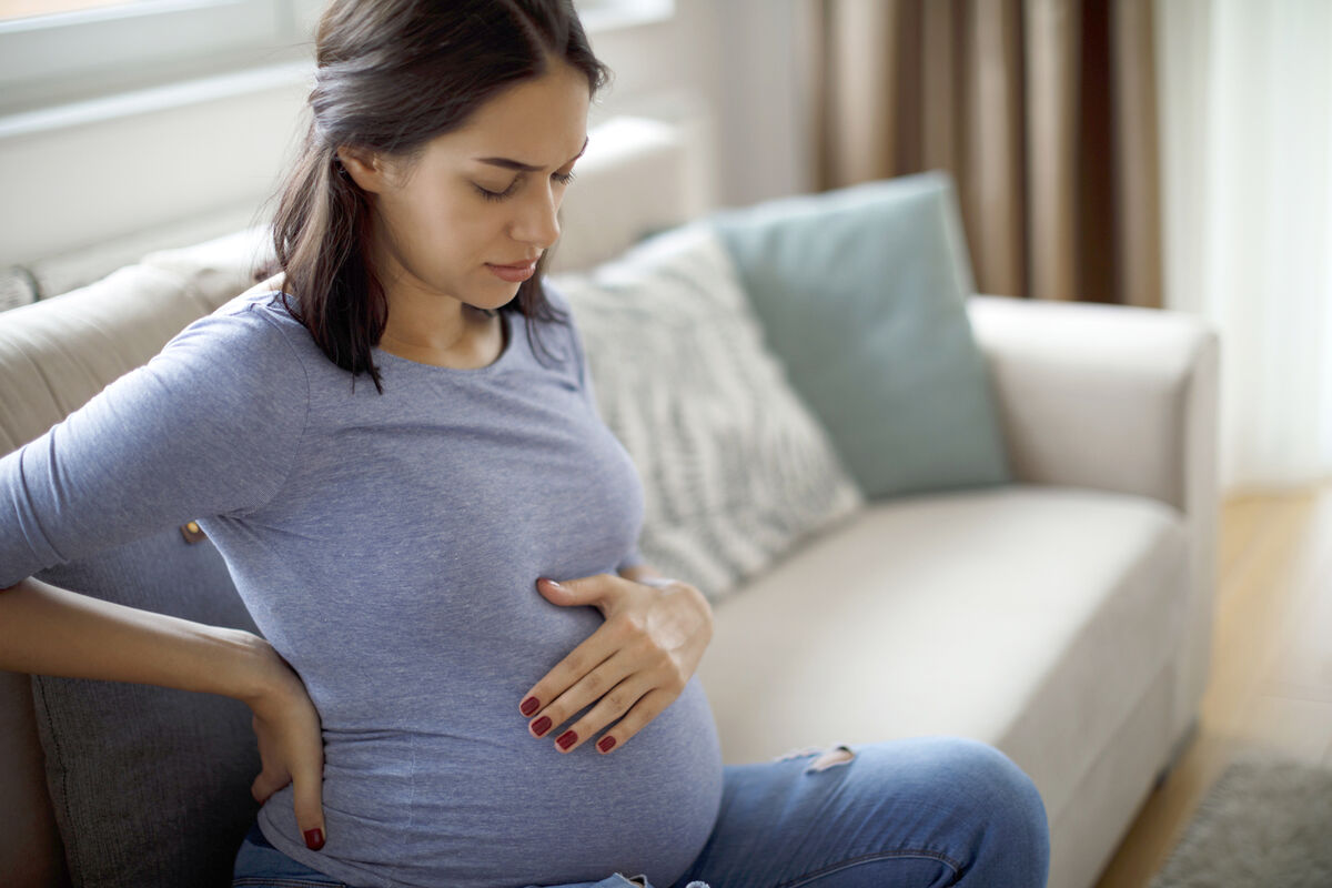 Young pregnant woman suffering from cramps