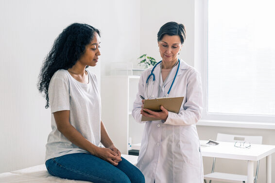 Patient in early pregnancy visiting doctor office and telling about symptoms