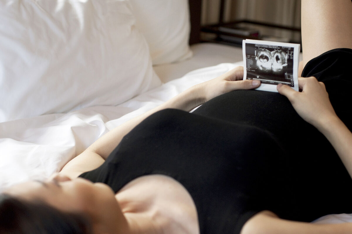 Pregnant woman holding a sonogram of a baby