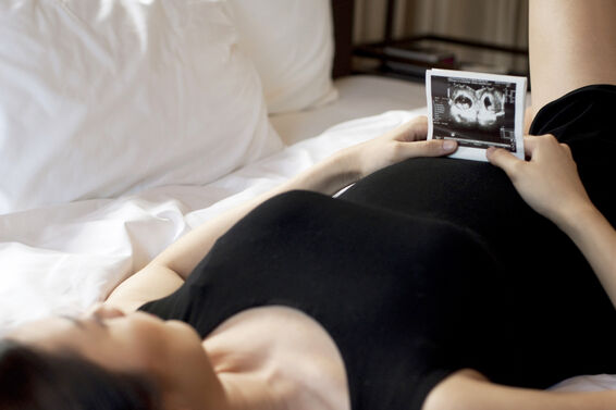 Pregnant woman holding a sonogram of a baby