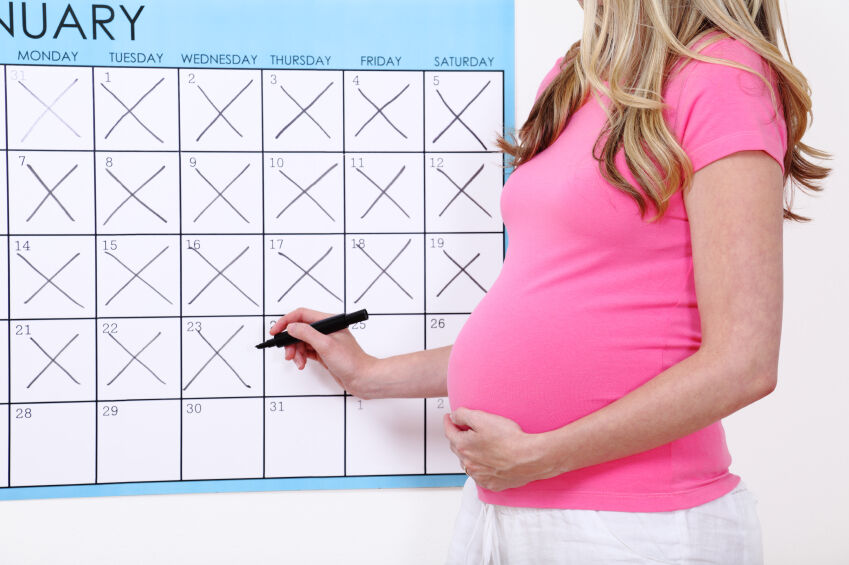 Pregnant woman marking down the calendar