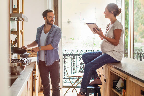 couple looking at tablet planning pregnancy milestones