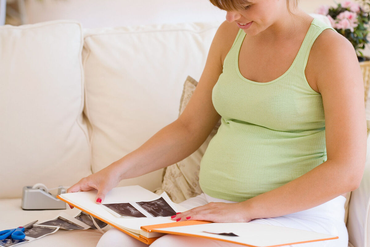 pregnant woman making scrapbook of pregnancy milestones