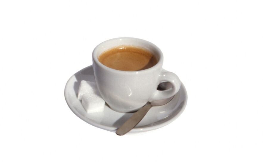 A cup of coffee and two sugar cubes