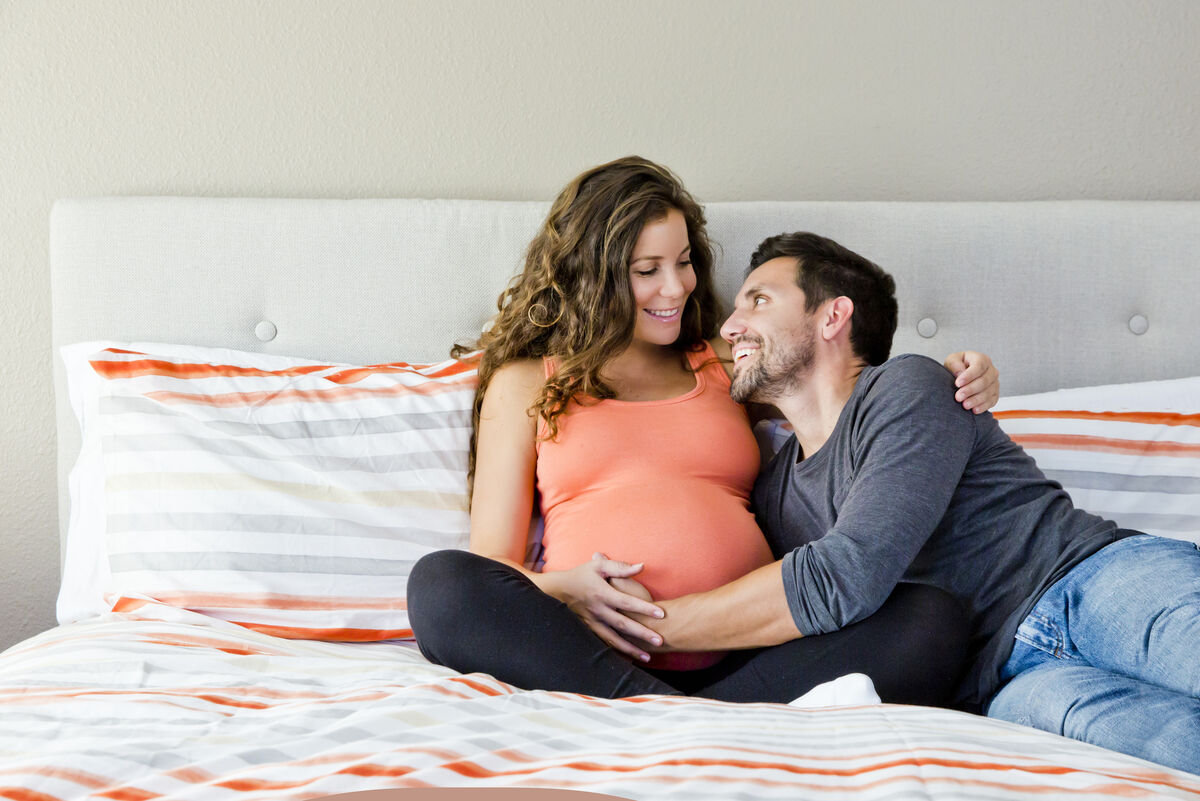 Pregnant Couple Sitting on Bed