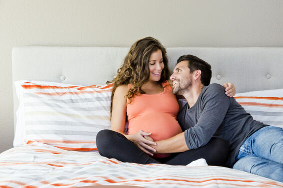 Pregnant Couple Sitting on Bed