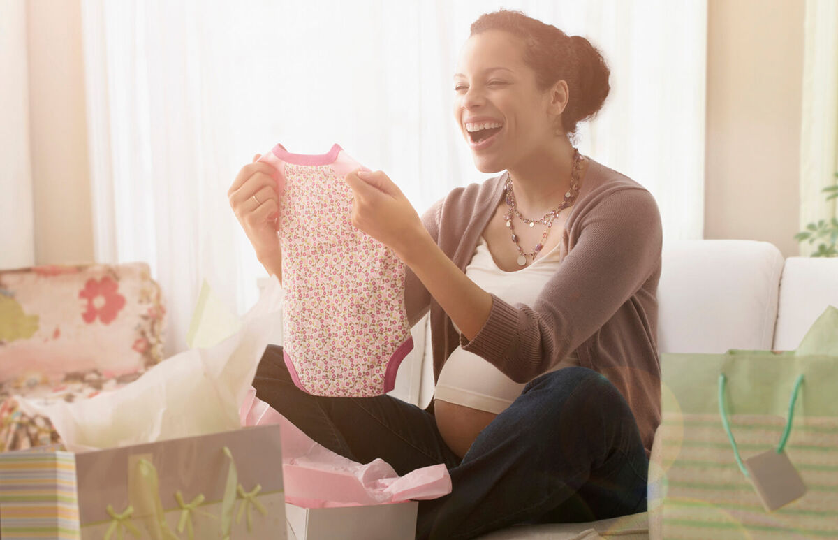 Pregnant woman opening gifts at baby shower