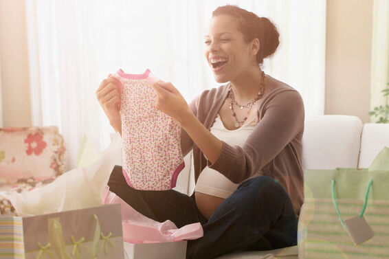 Pregnant woman opening gifts at baby shower