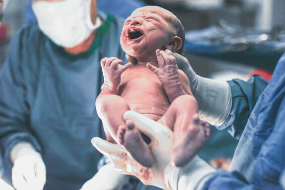 Doctors holding newborn baby boy