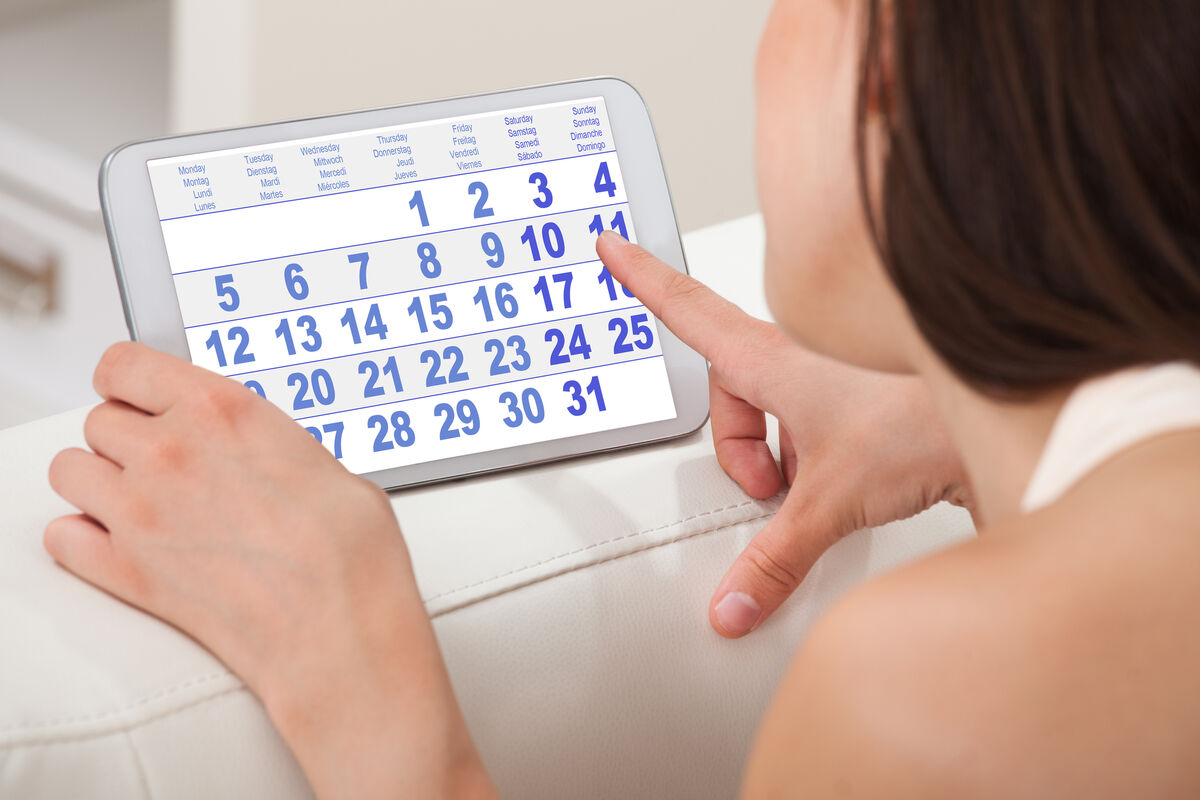 Woman Using Calendar On Tablet
