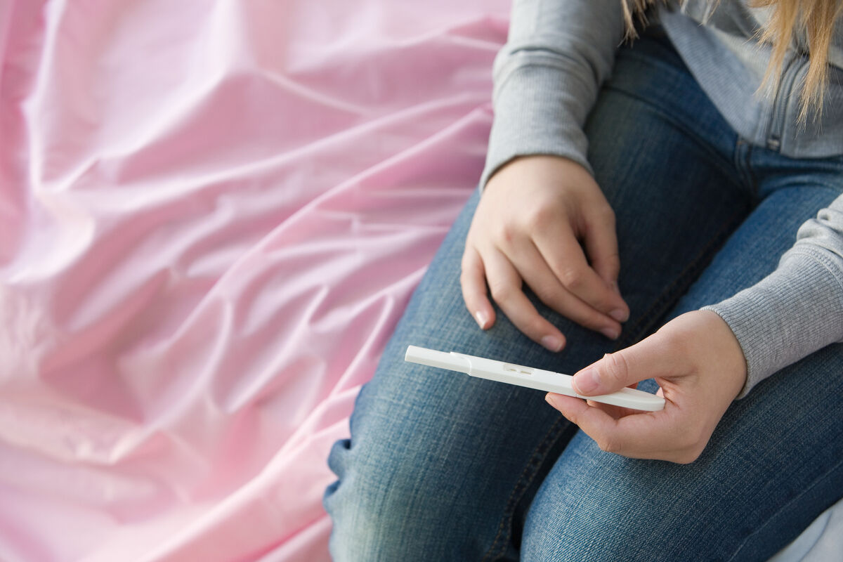 teenage girl holding pregnancy test