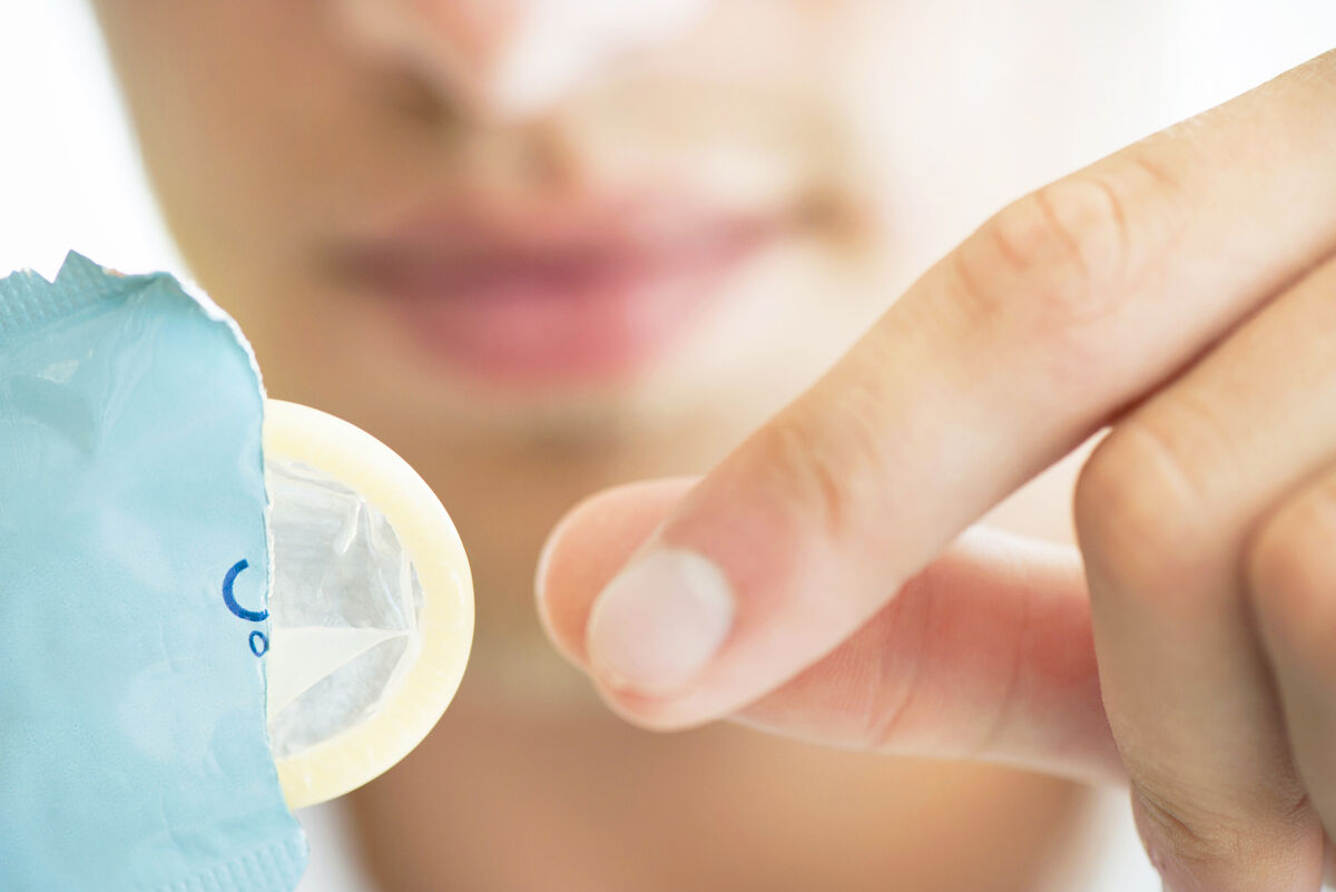 Woman removing condom from wrapper