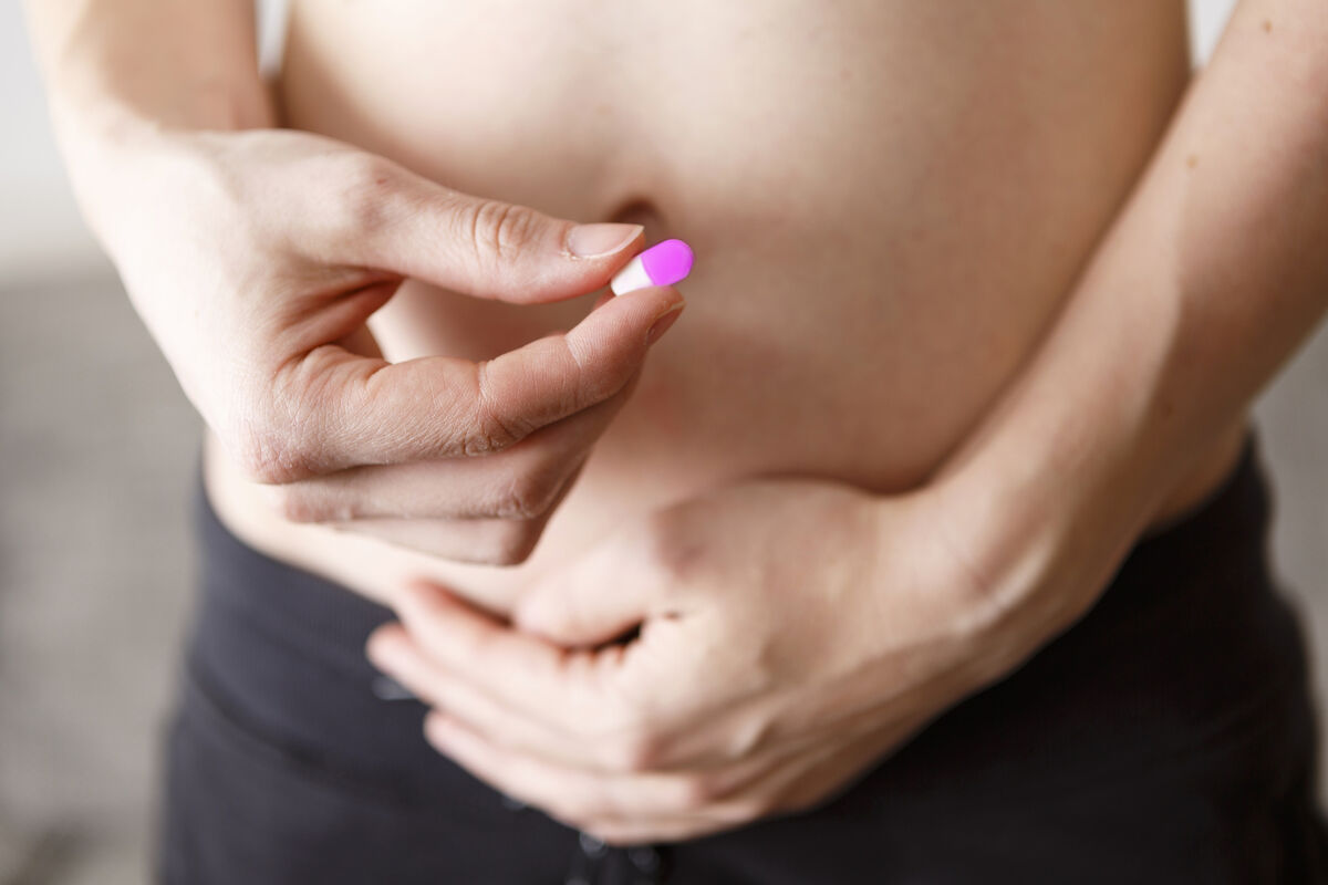 Pregnant woman with pill in her hand