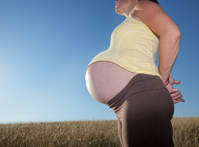 Pregnant belly carried out front; © Jared Alden | Dreamstime.com