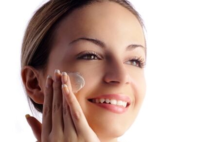 woman applying product to face