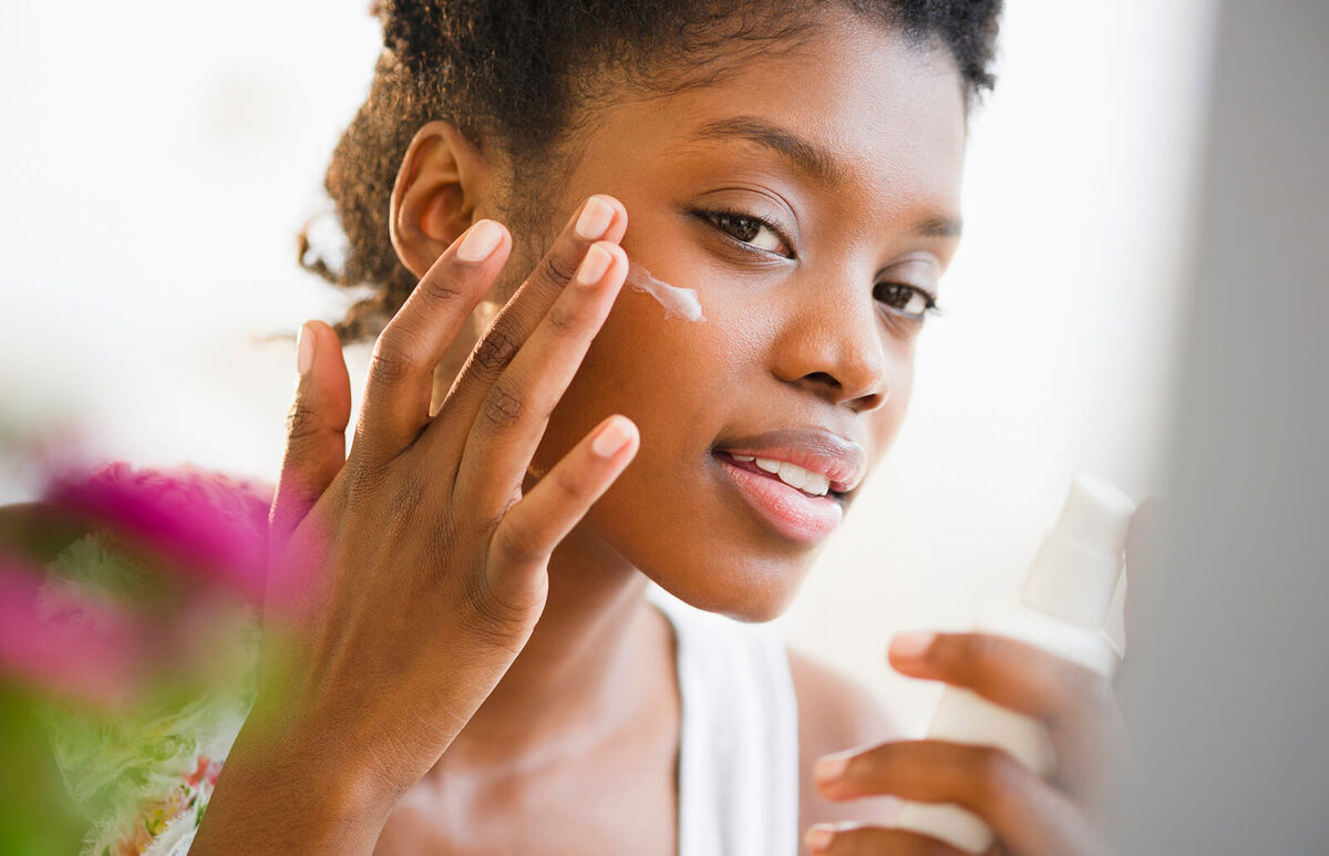 Woman putting on face lotion