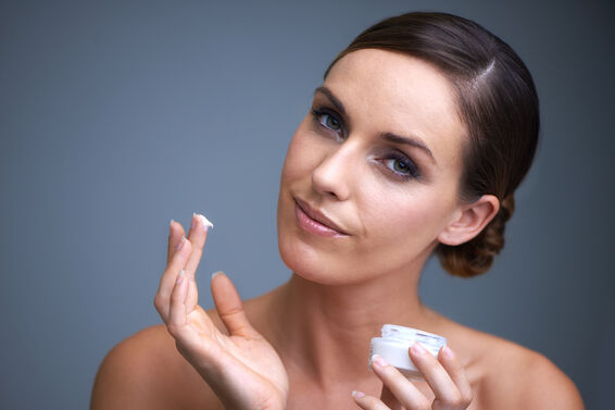 woman applying moisturizer to skin