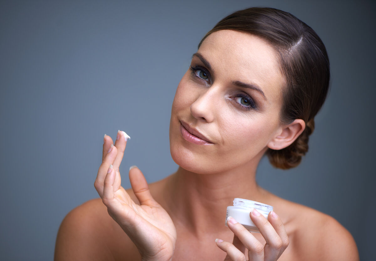 woman applying moisturizer to skin