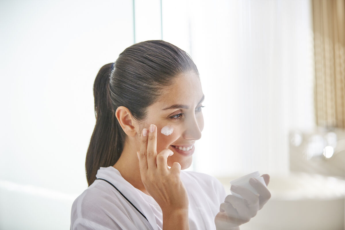 Woman applying face cream
