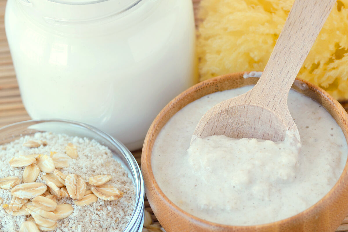 Oatmeal face mask in wooden bowl with spoon