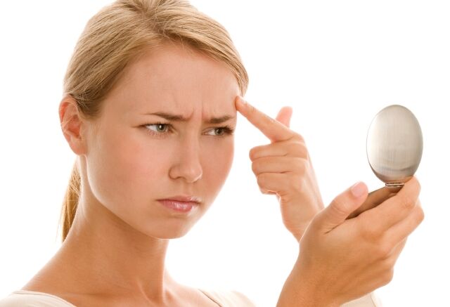 woman looking at a blemish